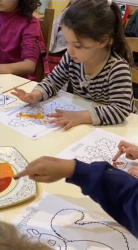 Niña coloreando dibujo de hojas otoñales