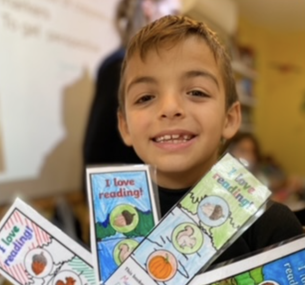 Niño contento detrás de varios marcapáginas