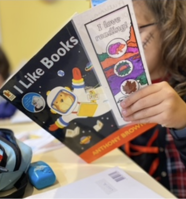 Mano sujetando folleto y marcapáginas